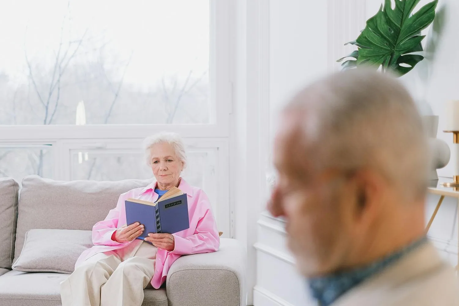 Seniorenpaar entspannt in einem hellen, modernen Wohnzimmer