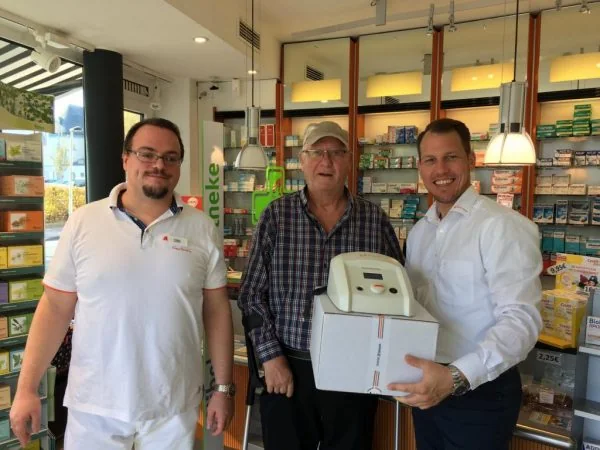 Gewinner Karl-Heinz Königsmann nimmt sein HiToP® 191 in der Nibelungen-Apotheke Solingen entgegen