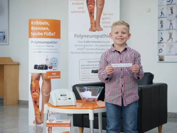 Junge zieht das Gewinnerlos für das Sommergewinnspiel 2018 aus einer Schüssel